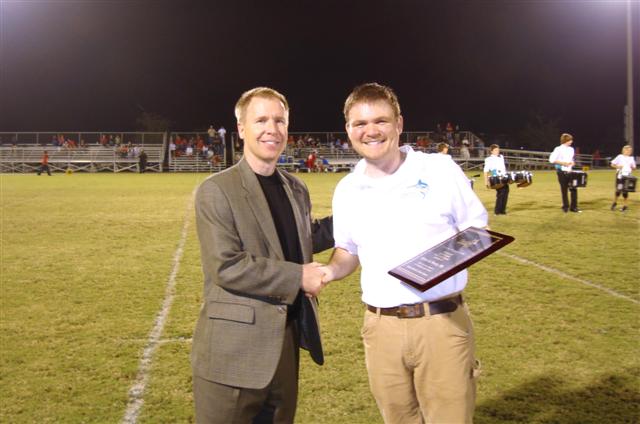 Pleat & Perry accepts plaque from Destin Middle School Band Director
